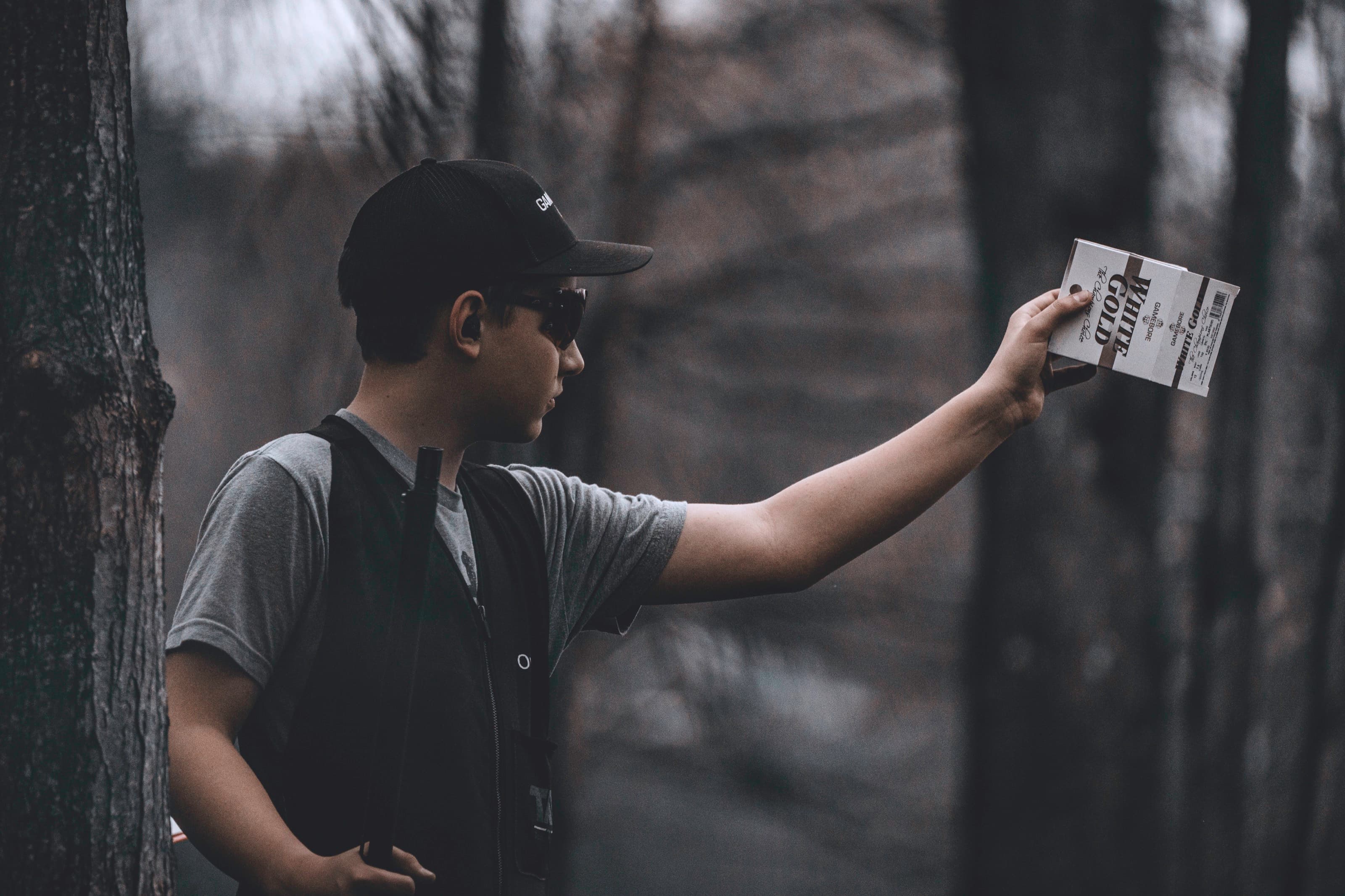 A shooter raises a shotgun in a dark, smoky field.