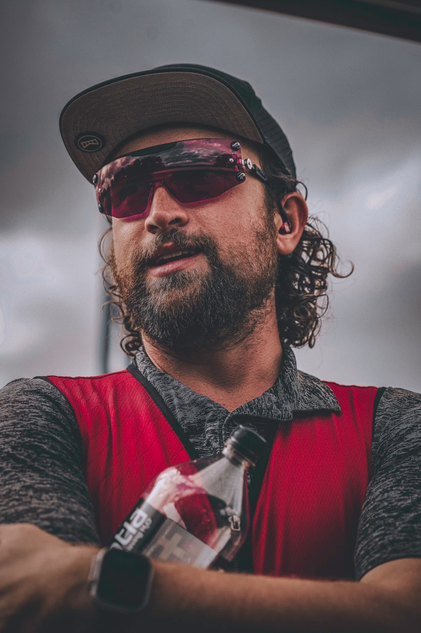 A close portrait of David in shooting glasses and a red vest.