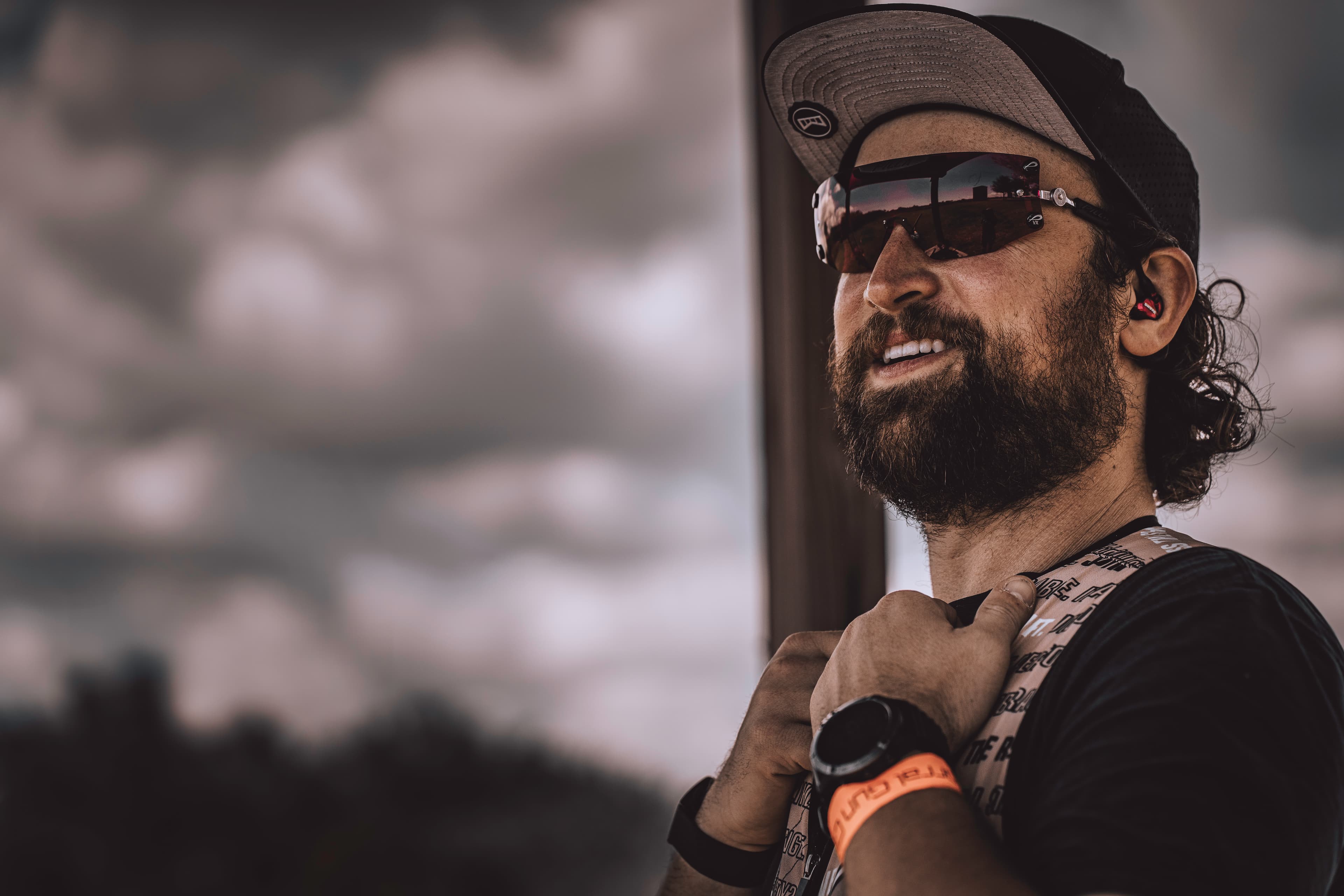 A close portrait of David wearing sunglasses beside a window.