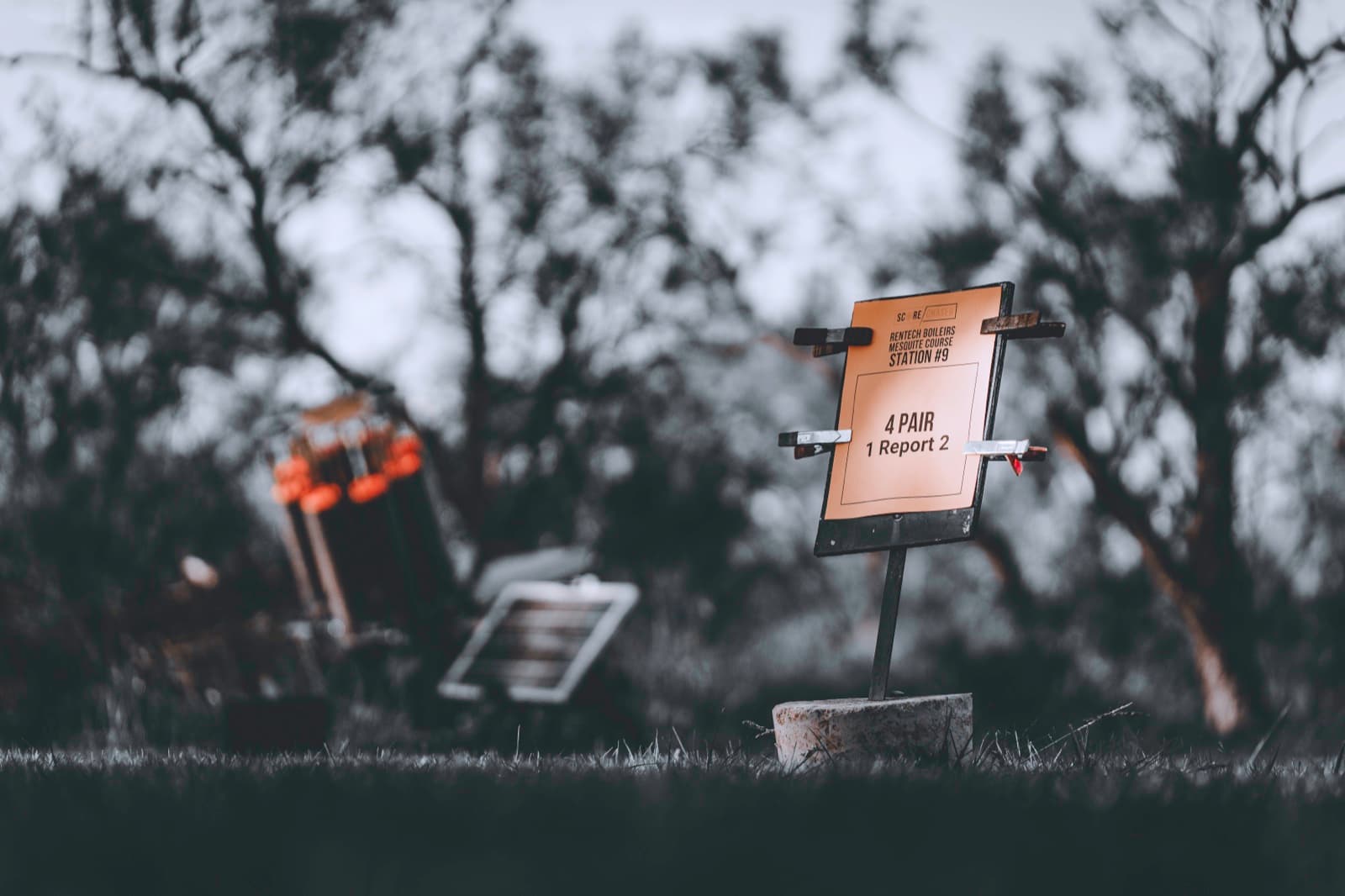 A field station sign held against dark trees.