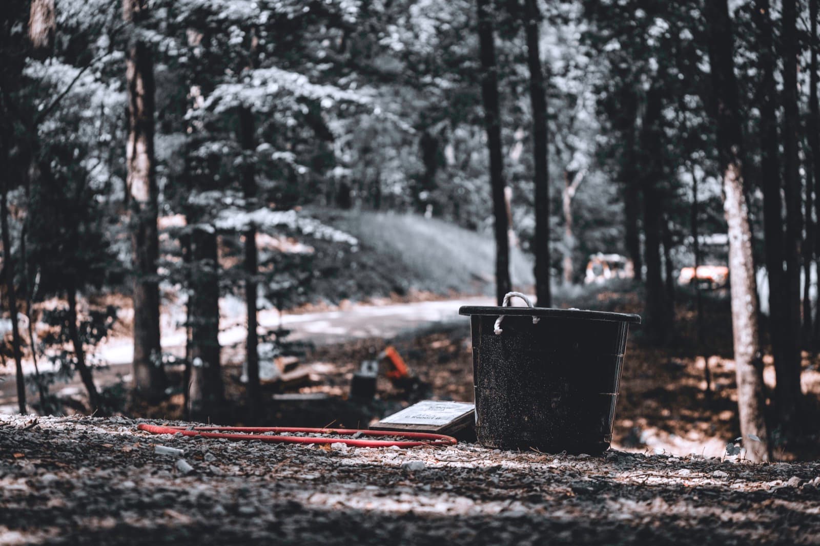 A field bucket and equipment resting in a wooded station.
