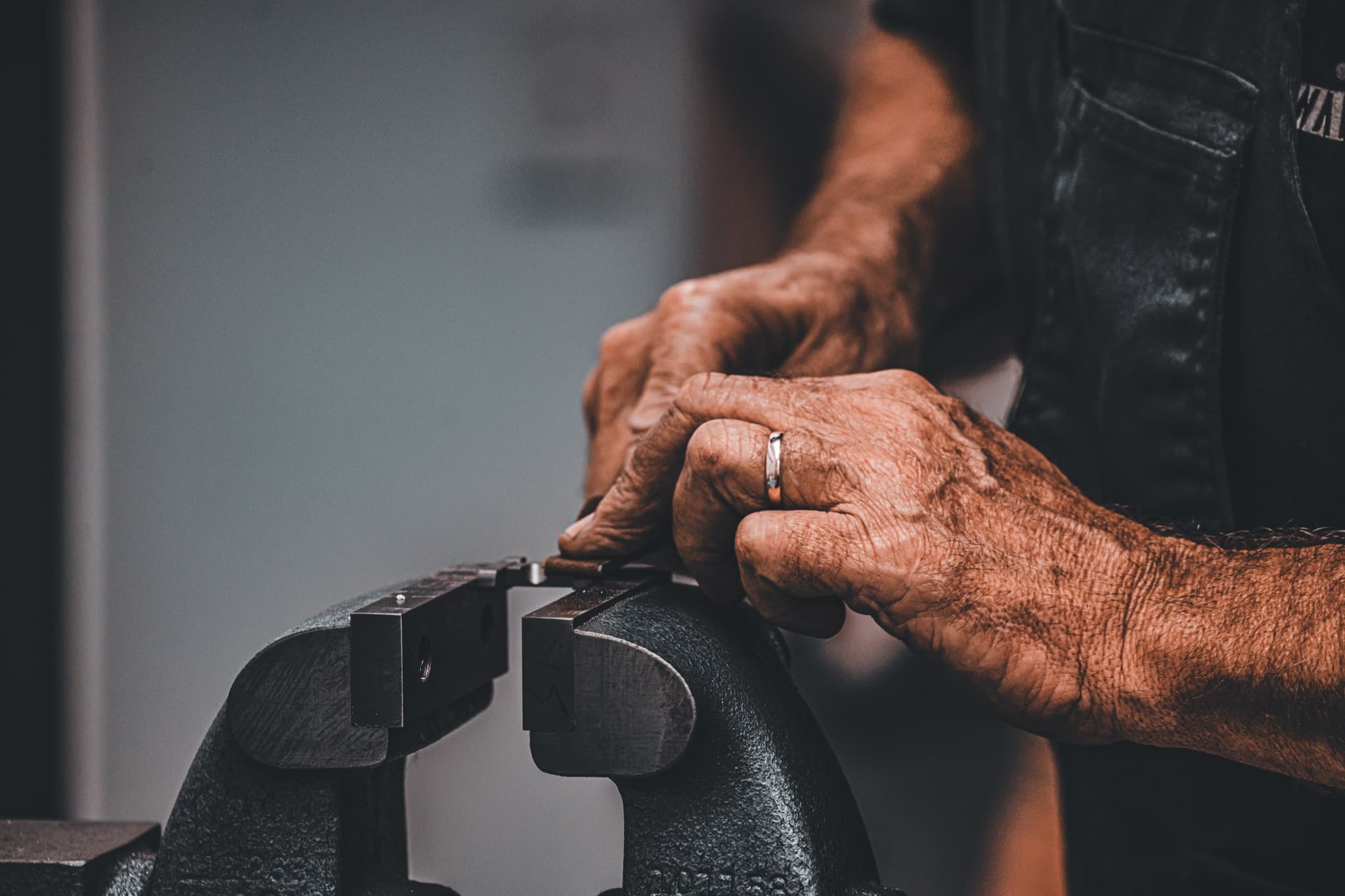 Hands adjusting a shotgun component during equipment work